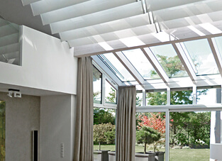 Moderner Wintergarten mit Vorhängen in Creme und Skylight-Schwenk-Paneele in weiß.