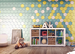 Ausschnitt eins Kinderzimmert mit breiten Holzdielen, großer Kuscheltiergiraffe und weißem mit Spielzeug gefülltem Regal. Im Hintergrund eine Wand mit modernen Wandpanelen bestehend aus Hexagone in blau, weiß und gelb.
