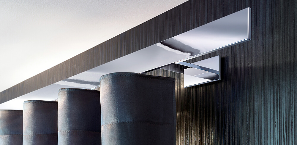 Designbeispiel Vorhangschiene Silber Hochglanz geradlinig, montiert auf schwarzer Wand und dunklem Waves Vorhang.