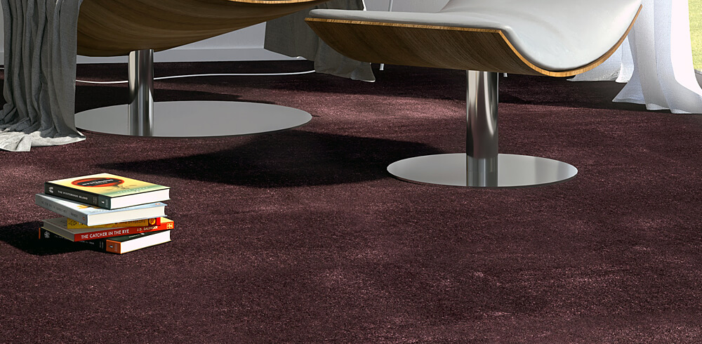 Designbeispiel von einem rot braunem Teppich. Darauf liegend ein kleiner Stapel Bücher. Angedeutet zu sehen Enden von Vorhängen und die silbernen Standfüße zweier Möbelstücke.