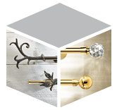 Eine stilisierte, isometrische Würfeldarstellung, die verschiedene Vorhangschienen und -stangen auf der Website von Zimmermann Interior Design zeigt. Die linke Seitenfläche präsentiert dunkle, schmiedeeiserne Endstücke im rustikalen oder floralen Design vor einer hellen Holzstruktur. Die rechte Seitenfläche zeigt glänzende goldfarbene Gardinenstangen mit modernen Endstücken, darunter eine kristallkugelartiges Endstück und eine runde, polierte Kugel. Die obere Fläche ist neutral grau.