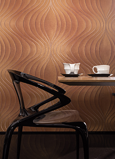 Designbeispiel der Marburg Colani Evolution Tapete. Orange Wand mit einem schwarzen stilvollem Stuhl und einem Tisch mit Tassen davor. Die Tapete ist in einem orange beige und hat senkrechte Wellenlinien darauf.